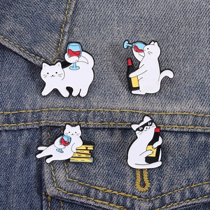 Détail de pin's chat blanc rigolo avec du vin et des livres sur veste en jean
