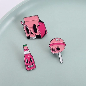 Roze schedel emaille pinnen met melkpak frisdrankfles en lolly ontwerpen op een dienblad