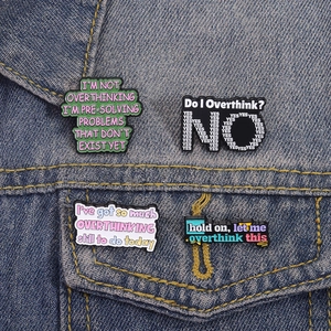 Set of four Overthinking enamel pins displayed on a blue denim jacket for accessory styling
