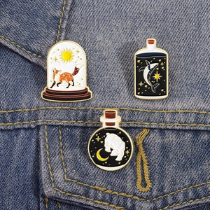 Vista dettagliata delle spille smaltate volpe balena e orso polare su denim blu jeans