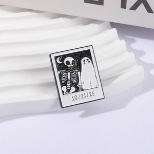 Halloween polaroid style enamel pin with skull and ghost silhouettes on white display