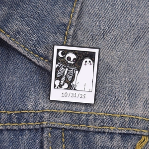 Detail of square Polaroid-style Halloween ghost pin on a denim jacket