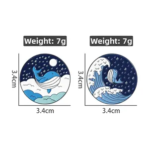Detail view of 3.4cm round blue whale enamel pins showing starry night and ocean wave patterns
