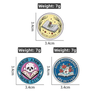 Detailed view of three circular enamel pins with creative book club slogans and motifs