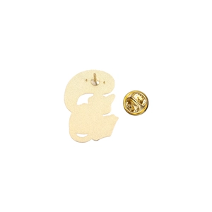 Detailed back view of golden metal brooch with butterfly clutch and security pin