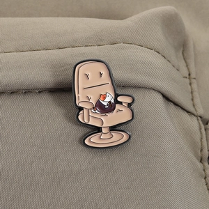 Detailed view of cartoon cat office chair enamel pin on a textured brown canvas background