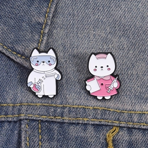 Detailed view of enamel cat pins featuring scientist and nurse designs on denim fabric