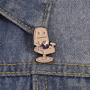 Detail of calico cat boss enamel pin on denim jacket showing vibrant office chair design