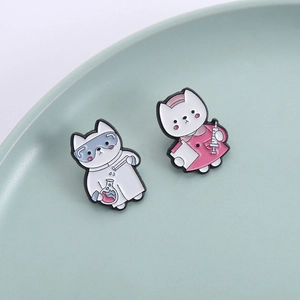 Cute enamel cat pins featuring scientist and nurse designs on a ceramic tray