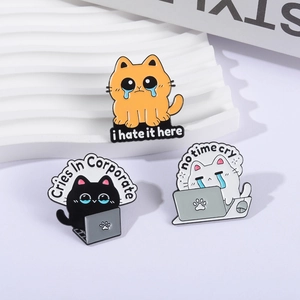 Three enamel cat pins with workplace humor quotes displayed on a white textured tray