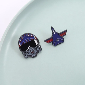 Aviation fighter jet and pilot helmet enamel pins set on a light green ceramic tray