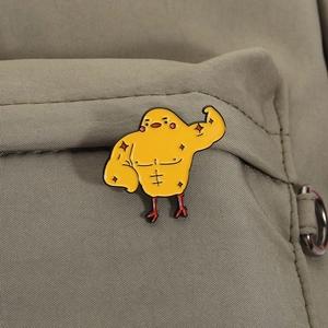 Gros plan d'un pin's en émail poussin musclé sur un sac en toile kaki durable
