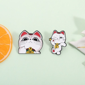 Cute Maneki Neko lucky cat enamel pin set with gold coins on a fresh green background