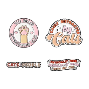 Set of four cute cat-themed enamel pins featuring paw prints and funny feline quotes