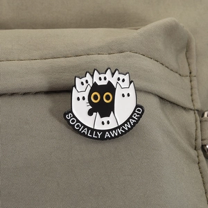 Détail du pin's émaillé Socially Awkward avec chats sur un tissu en toile verte
