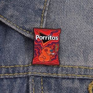 Dettaglio della spilla smaltata con castoro divertente su giacca di jeans blu
