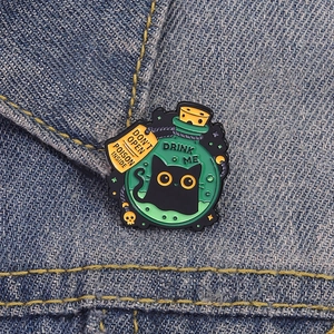 Dark magic black cat potion enamel pin with skull pendant on blue denim background