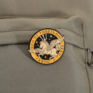 Macro shot of Poseidon's Son enamel pin featuring Pegasus on green canvas fabric