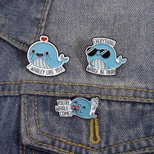Three cute whale enamel pins with funny puns on denim background for clothes decoration