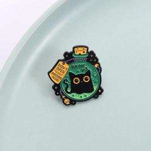 Funny enamel cat magic potion bottle pin with Drink Me text on green background