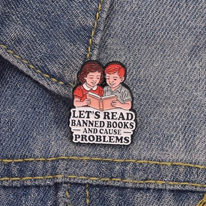 Macro de l'épingle émaillée rétro Let's Read Banned Books sur veste en jean