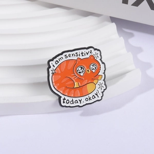 Cute orange cat enamel pin featuring crying expression and sensitive quote for bags