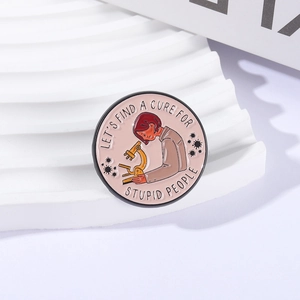 Round enamel pin with scientist and microscope featuring Let's Find A Cure For Stupid People slogan
