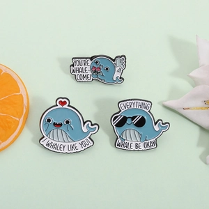 Three cute blue whale enamel pins with funny puns and hearts on a fresh pastel background