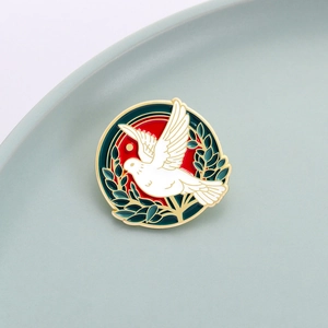 Broche artístico de esmalte de paloma blanca con rama de olivo y fondo de sol rojo
