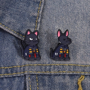 Detail von Emaille-Pins auf Jeansjacke mit anatomischen Katze- und Hund-Motiven