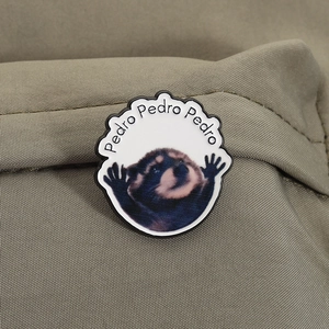 Macro detail of round enamel pin featuring a Pedro raccoon meme on khaki canvas fabric