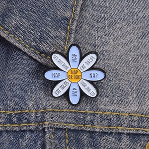 Daisy enamel pin with funny NAP slogans on a blue denim jacket collar for creative styling