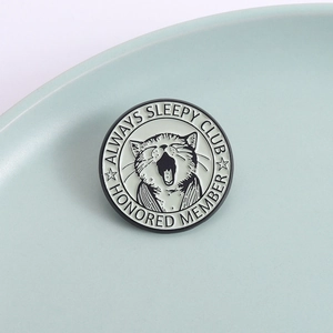 Lazy cat yawn enamel pin badge with Always Sleepy Club text in monochrome black and white