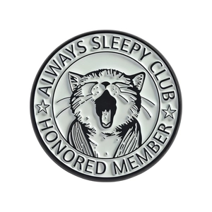 Round black and white enamel pin featuring a yawning cartoon cat with starry accents