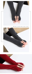Close-up of knit arm warmers with thumb holes in dark grey and red colors