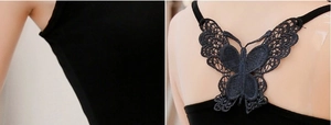 Detail of elegant black butterfly lace embroidery and criss-cross straps on the back