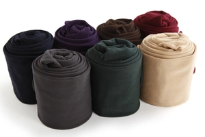 Close-up of rolled winter thermal leggings showing multiple colors and soft brushed texture