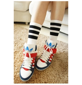 Nahaufnahme von Retro-Streifensocken kombiniert mit klassischen High-Top-Sneakern