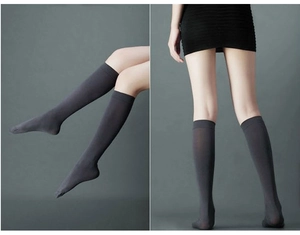 Detail of dark charcoal knee-high compression socks with wide non-slip ribbed cuffs