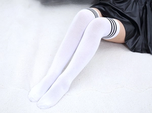 Détail de chaussettes hautes blanches en coton avec trois rayures sportives noires