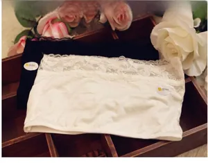 Close-up of black and white lace tube tops with eyelash lace trim in a wooden box