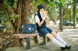 Detailed view of dark navy Japanese school uniform socks with a pleated skirt and bag