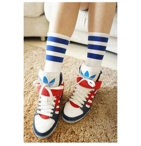 Nahaufnahme von Retro High-Top Sneakern im Trikolore-Design und gestreiften Socken