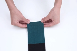 Détail du bord-côte élastique sur les chaussettes hautes rayées vert et noir