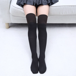 Détail de chaussettes hautes noires en coton avec revers antidérapant et fini mat