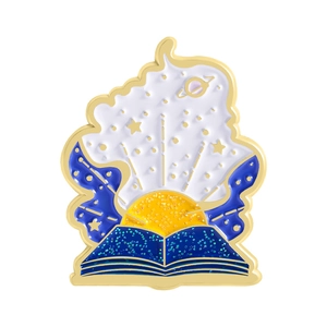 Starry sky and planet enamel pin designed as an open magic book with golden finish