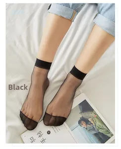 Detail of sheer black summer ankle socks with reinforced toes on a white bed