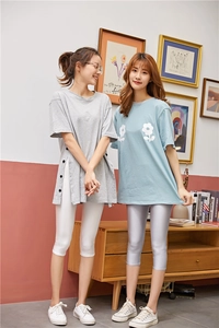 Close-up of slim leggings paired with a grey T-shirt featuring stylish side buttons