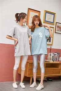 Side view of women's glossy cropped leggings paired with a loose casual t-shirt