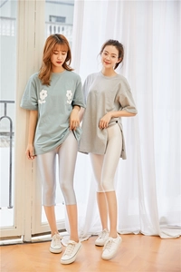 Close-up of shiny cropped leggings paired with oversized printed t-shirts in soft indoor light